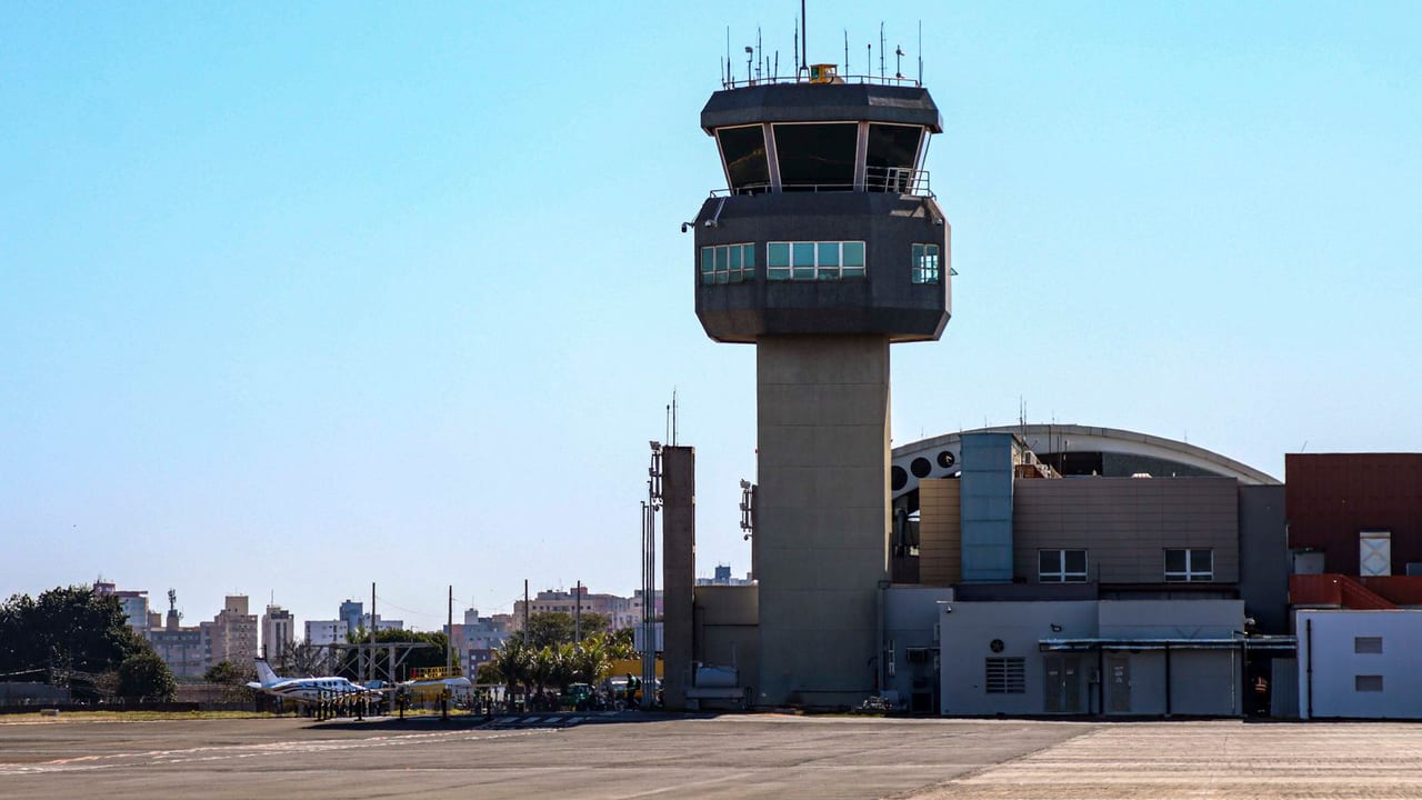 An airport control tower against a clear blue sky